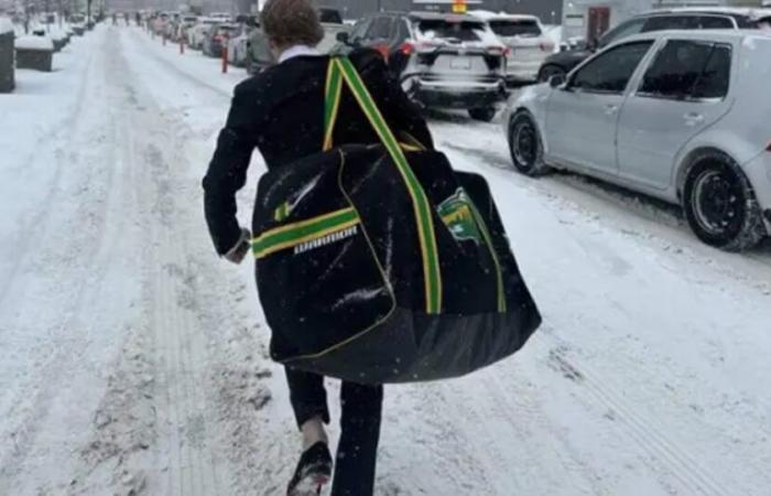 Der wilde Spieler muss mit seiner Hockeytasche durch den Verkehr gehen, um zu seinem ersten Spiel zu gelangen