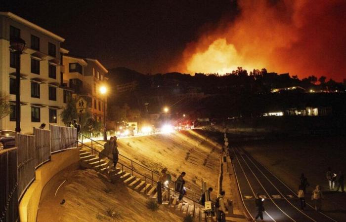 Durch ein Fenster beobachten Pepperdine-Studenten, wie das Feuer in Malibu den Campus verwüstet