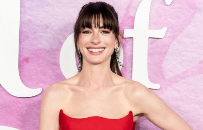 Anne Hathaway, wider Willen eine Prinzessin in einem goldenen trägerlosen Kleid, das ihre Schultern freigibt, sie ist göttlich