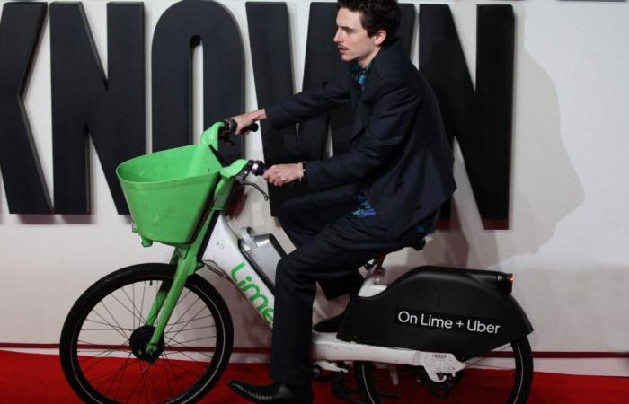 als Schauspieler Timothée Chalamet mit dem Fahrrad auf dem roten Teppich in London ankommt