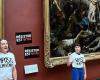 Im Louvre kleben Aktivisten von Food Response Plakate neben dem Gemälde „Freiheit führt das Volk“