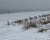 Beobachten Sie den Schnee am Strand, während der Wintersturm die Golfküste heimsucht